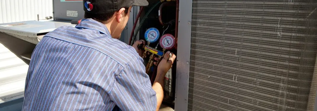 HVAC technician servicing a condenser unit in Stallings
