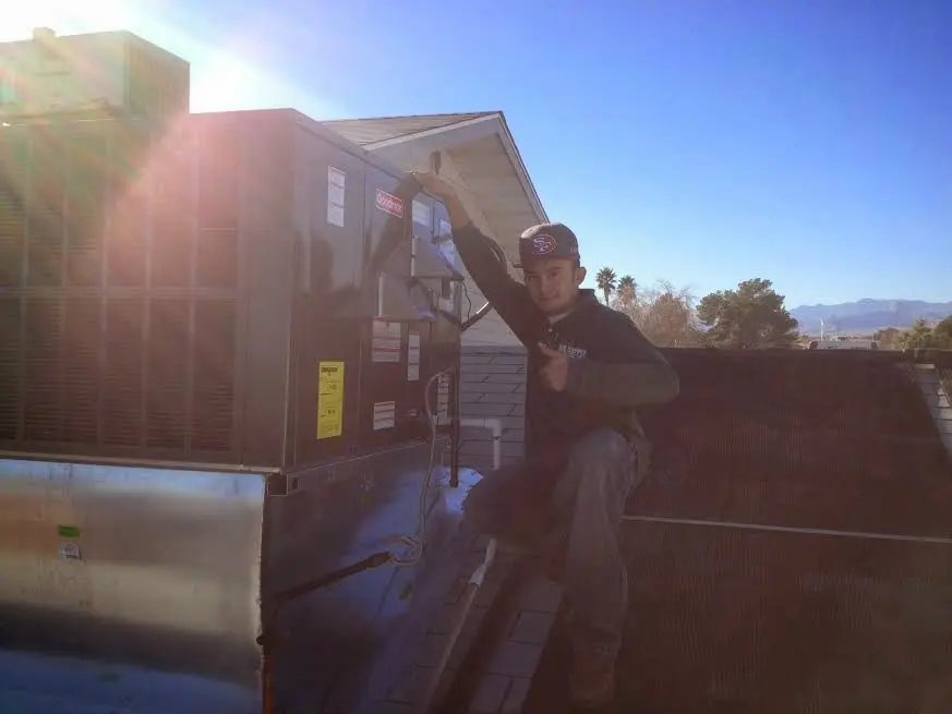 HVAC technician performing Boiler Repair on a rooftop unit in Stallings